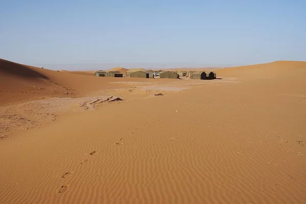 Afrika 'nın güneydoğusundaki Sahra Çölü' ndeki Erg Chigaga kumullarında berber kampı, 2023 yılının sıcak ve güneşli kış gününde açık mavi gökyüzü..