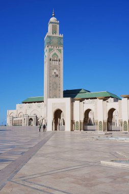 Fas 'ta Afrika Kazablanka şehrinde minareli Hasan II camii, Ocak' ta sıcak ve güneşli 2023 'te açık mavi gökyüzü - dikey