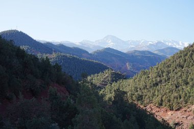 Fas 'ın Marakeş şehri yakınlarındaki Ourika Vadisi' ndeki dağlar, 2023 'ün ılık ve güneşli kış gününde açık mavi gökyüzü..