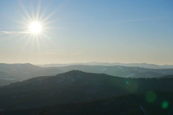 stock image Sun on sky over Silesian Beskid Mountains near european Bialy Krzyz at Szczyrk in Poland, clear blue sky in 2022 cold sunny winter day on February