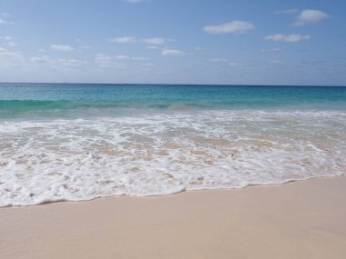 Cape Verde 'de Sal Adası' ndaki Afrika Santa Maria kasabasında sakin dalgalar, 2019 'da açık mavi gökyüzü Nisan ayında güneşli bahar günü.