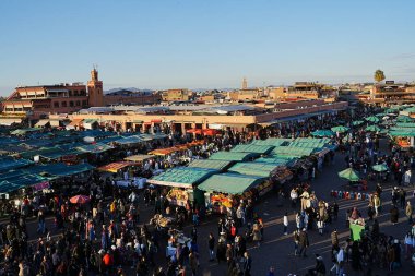 MARRAKESH, MOROCCO - 28 HAZİRAN 2023: Afrika şehrindeki Djema el-Fna Meydanı, ılık güneşli kış gününde açık mavi gökyüzü.