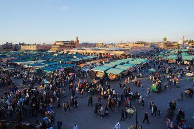 MARRAKESH, MOROCCO - 28 HAZİRAN 2023: Afrika kenti Jemaa el-Fnaa 'daki pazar yeri, ılık güneşli kış gününde açık mavi gökyüzü.
