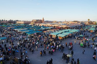 MARRAKESH, MOROCCO - 28 HAZİRAN 2023: Afrika 'nın Medine kentindeki Jemaa el-Fnaa' nın ünlü meydanı, ılık güneşli kış gününde açık mavi gökyüzü.