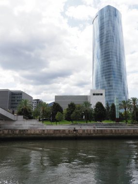 Nervion nehri ve Iberdrola kulesi Avrupa 'nın BILBAO şehrinde, Biscay, İspanya, 2019' da bulutlu mavi gökyüzü sıcak yaz günü Eylül - dikey