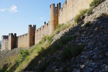 PORTUGAL 'in Santarem ilçesindeki Avrupa TOMAR şehrinde İsa' nın manastırının savunma duvarları, 2022 'nin güneşli bahar gününde açık mavi gökyüzü.