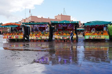 MARRAKESH, MOROCCO - 27 HAZİRAN 2023: Yağmurdan sonra Afrika şehrinde Jemaa el-Fnaa 'da gıda çarşısı, ılık, güneşli kış gününde açık mavi gökyüzü.