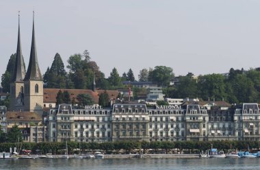 LUCERNE, SWitzERLAND - 6 Ağustos 2018: Avrupa 'da sıcak yaz gününde St. Leodegar Kilisesi ve otel.