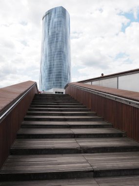 Manzaralı Abandoibarra köprüsü, Avrupa 'nın BILBAO şehrinde iberdrola kulesi, İspanya' nın Biscay kenti, 2019 yılının güneşli yaz günü bulutlu gökyüzü - dikey