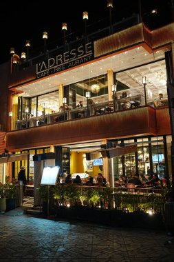 MARRAKESH, MOROCCO - 25 JANUARY 2023: Luxury restaurant on Jemaa el-Fnaa in African city at evening winter day - vertical clipart