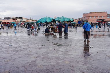MARRAKESH, MOROCCO - 27 JANUARY 2023: View to Jemaa el-Fnaa in African city after rain, cloudy sky in warm winter day. clipart