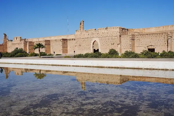 stock image El Badi palace reflected in water with stork's nests in African MARRAKESH city in MOROCCO, clear blue sky in 2023 warm sunny winter day on January.