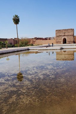 Fas 'taki Afrika MARRAKESH şehrindeki El Badi Sarayı' nın batı köşkü, Ocak 'ta sıcak ve güneşli 2023' te açık mavi gökyüzü - dikey