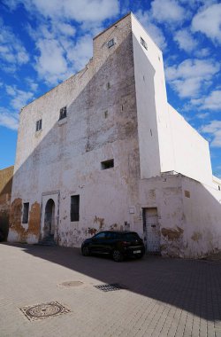 EL JADIDA, MOROCCO - 29 Ocak 2023: Afrika MAZAGAN şehrinde köşe binası, ılık güneşli kış gününde açık mavi gökyüzü - dikey