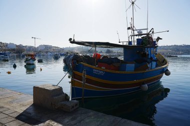 Geleneksel balıkçı teknesi Malta 'nın Marsaxlokk köyünde demirlemiş.