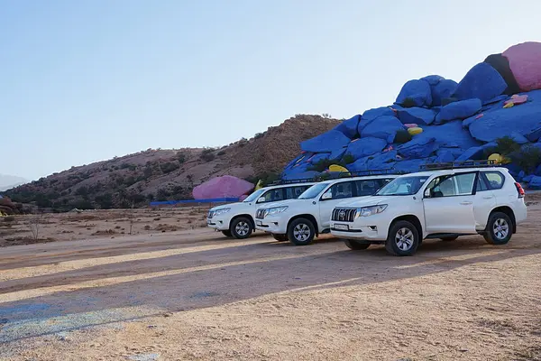 stock image TAFRAOUT, MOROCCO - January 22nd 2023: Three off-road cars near African town at Tiznit province, Souss-Massa, clear blue sky in warm sunny winter day.