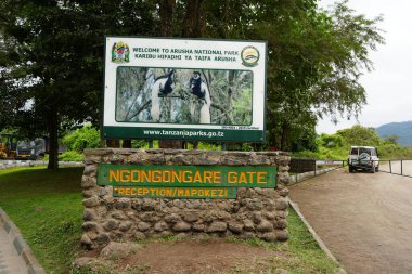 ARUSHA, TANZANIA - July 19th 2024: Entrance board of African national park, cloudy sky in warm winter day. clipart