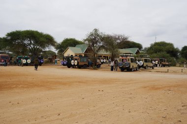 ARUSHA, TANZANIA - 20 Temmuz 2024: Manyara bölgesindeki Afrika Tarangire Milli Parkı 'nın girişi ve park yeri, sıcak kış gününde bulutlu bir hava.