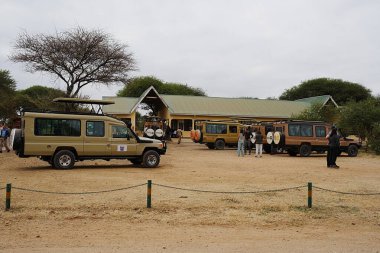 ARUSHA, TANZANIA - 20 Temmuz 2024: Manyara bölgesindeki Afrika Tarangire Milli Parkı 'nın park ve giriş binası, sıcak kış gününde bulutlu bir hava.