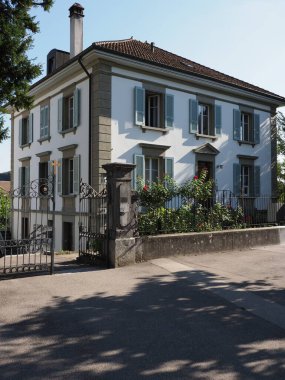 Old mansion in European Murten town at canton of Fribourg in Switzerland, clear blue sky in 2018 warm sunny summer day on August - vertical clipart