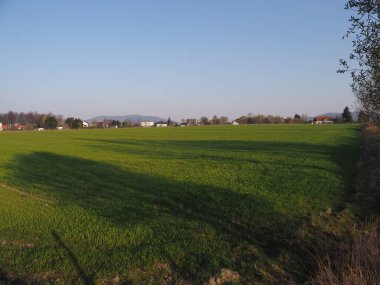 Shadow on grassy range seen from sport airfield in European Bielsko-Biala city in Poland, clear blue sky in 2020 warm sunny spring day on April. clipart