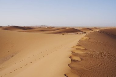 Afrika 'nın güneydoğusundaki Sahra Çölü' nde Erg Chigaga kum tepeciği, Ocak 'ın 2023' te güneşli bir kış gününde açık mavi gökyüzü..