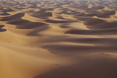 Afrika 'nın güneydoğusundaki Sahra Çölü' nde Erg Chigaga kum tepeciklerinin oluşturduğu alan, 2023 yılının sıcak ve güneşli kış gününde açık mavi gökyüzü.