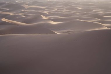 Afrika 'nın güneydoğusundaki Sahra Çölü' ndeki Erg Chigaga kumullarında güneş ışığı, Ocak 'ın 2023' te güneşli bir kış gününde açık mavi gökyüzü..