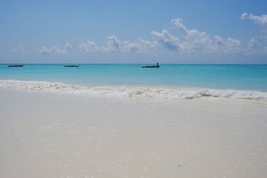 Tanzanya 'daki Afrika Zanzibar adasındaki Hint Okyanusu' ndaki Jambiani plajı ve balıkçı tekneleri, 2024 'te güneşli bir yaz gününde açık mavi gökyüzü..