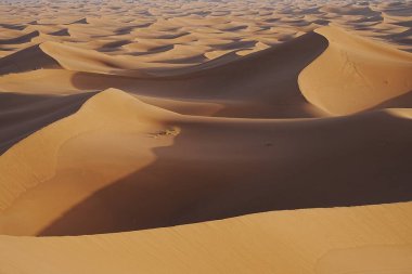 Afrika 'nın güneydoğusundaki Sahra Çölü' nde Erg Chigaga 'nın kum oluşumları tepeleri, 2023' te sıcak kış günü açık mavi gökyüzü.
