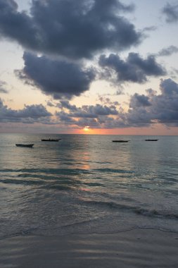 Hint Okyanusu üzerinde gün doğumuna ve Afrika Zanzibar Adası, Tanzanya 'daki balıkçı teknelerine bakın. 2024' te güneşli bir yaz günü, hava bulutlu. Dikey.