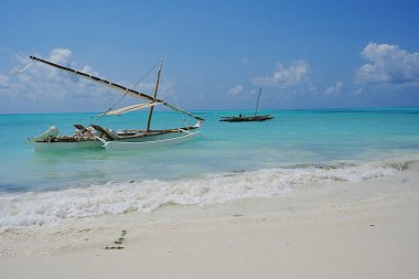 Tanzanya 'daki Afrika Zanzibar Adası' ndaki Hint Okyanusu 'ndaki Jambiani sahilindeki güzel balıkçı tekneleri, 2024' te güneşli bir yaz gününde açık mavi gökyüzü..