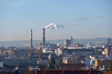 View of the city with a smoking chimney of a heating plant in Brno, Czech Republic. Gas heating plant provides heat to central part of city on winter morning.