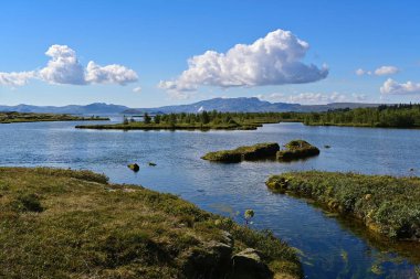 Thingvellir Ulusal Parkı, İzlanda 'da güzel bir manzara, gölü olan Thingvallavatn, dağ sırtları ve mavi gökyüzünde bulutlar. 