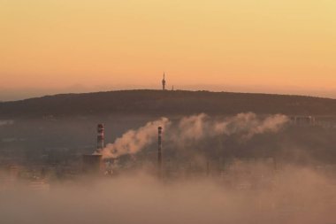 Çek Cumhuriyeti 'nin Brno kentindeki bir ısıtma tesisinden gelen dumanla sisli bir sabahta şehrin manzarası