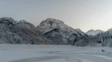 Kuzey İtalya 'daki donmuş Lago de Predil' i çevreleyen Julian Alpleri 'nin tepesinde alacakaranlık.
