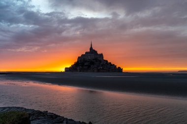Meşhur Mont-Saint-Michel alacakaranlıkta renkli bir gökyüzü ile.