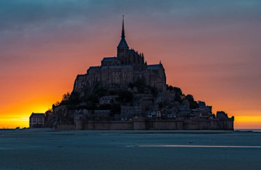 Meşhur Mont-Saint-Michel alacakaranlıkta renkli bir gökyüzü ile.
