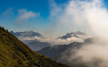 Monte Zermula 'dan güneye harika bir sonbahar manzarası. Etrafı bulutlarla çevrili bir sürü dağ var..