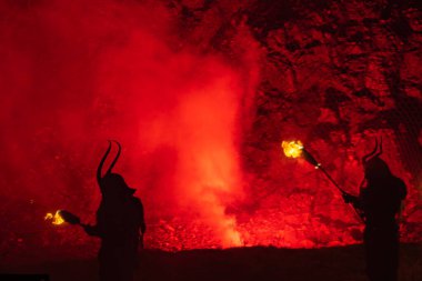 Krampus leaving the old mine in Cave del Predil in Northern Italy with lots of fire to accompany St. Nicholas clipart