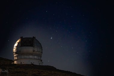 Gran Telescopio Canarias, dünyanın en büyük tek açıklıklı optik teleskobu, geceleyin yıldızlı bir gökyüzünün önünde..