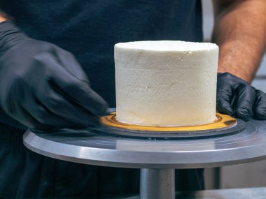 Profesyonel fırıncı çikolatalı ve kremalı pastayı tuzlu karamel ile süslüyor.