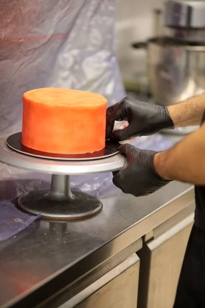 stock image cook preparing a red frosted cake using air bush