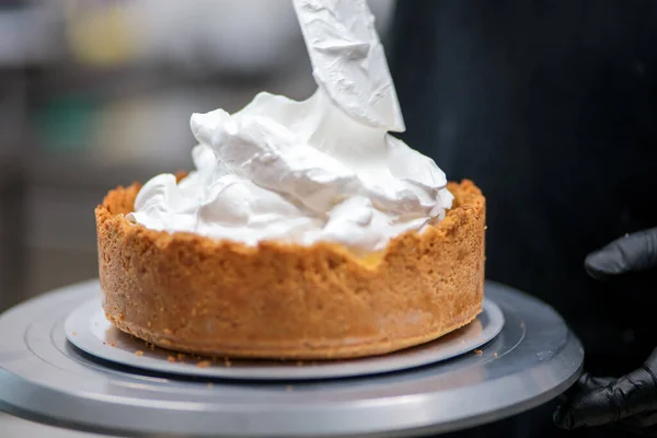 Yemek şefi profesyonel mutfakta limonlu turta hazırlıyor.