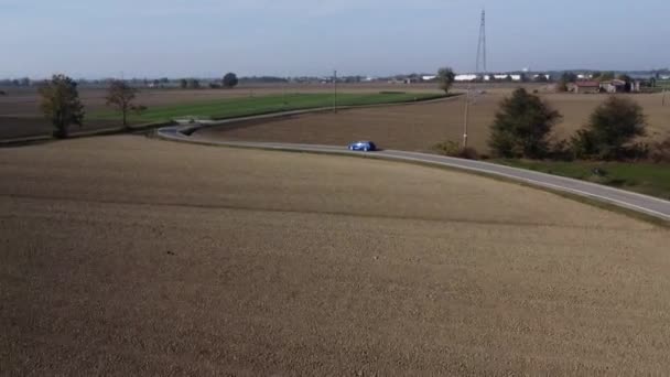 Letecký Pohled Modré Auto Cestující Venkovské Silnici Mezi Starými Farmami — Stock video