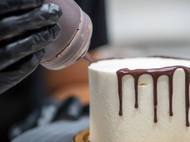 Tanınmayan bir işçi çikolatalı pasta ve dut hazırlıyor.