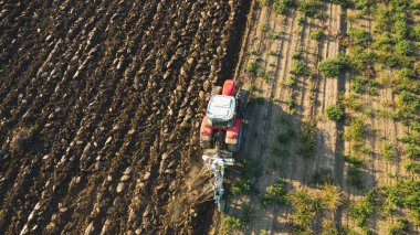 Hava manzaralı traktör dronu kırsal alanda toprağı sürüyor..