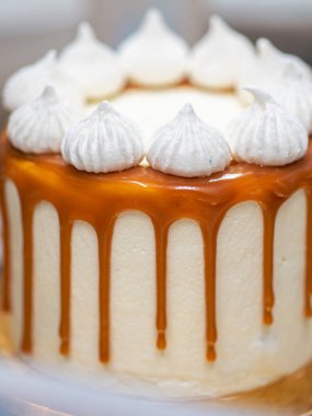 Profesyonel fırıncı çikolatalı ve kremalı pastayı tuzlu karamel ile süslüyor.