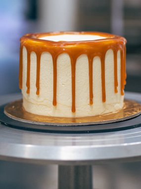 Profesyonel fırıncı çikolatalı ve kremalı pastayı tuzlu karamel ile süslüyor.