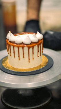 Şef kremalı pastanın üstünü dekore ediyor.